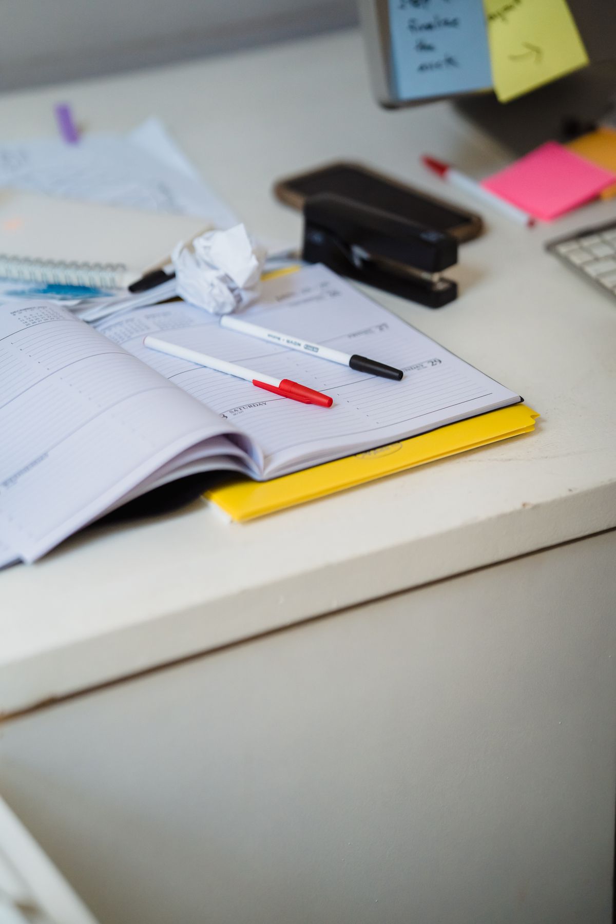 A planner and pens on a desk, ready for weekly scheduling