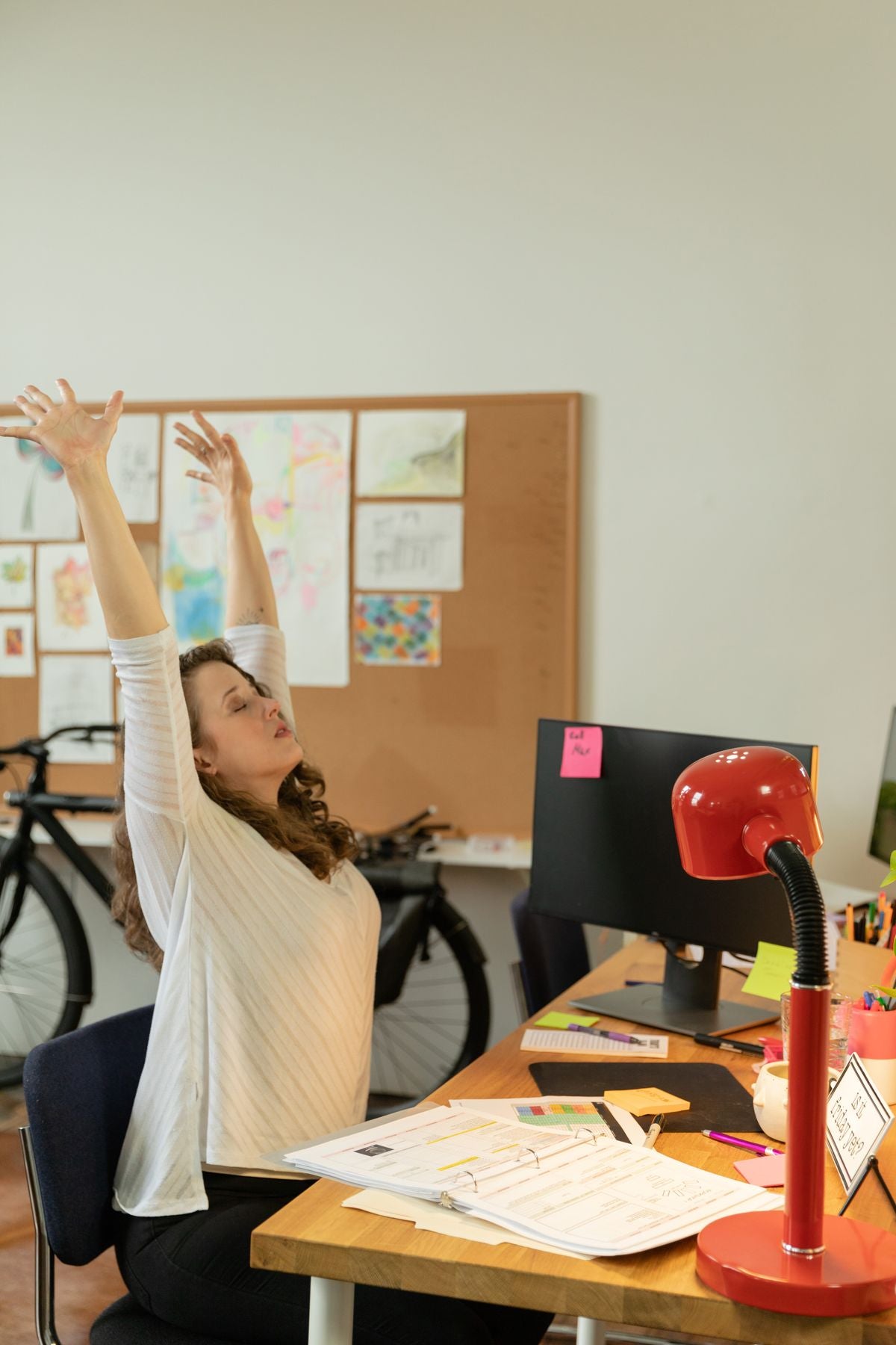 A person stretching at their desk while taking a study break